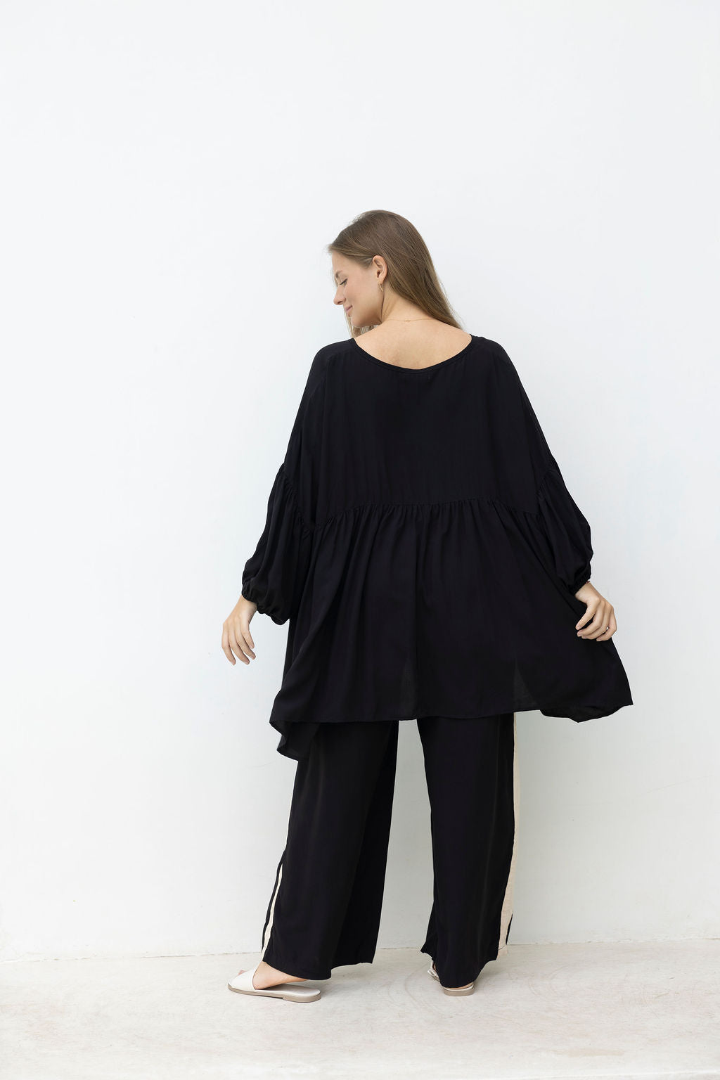 Woman wearing a black outfit against a white background