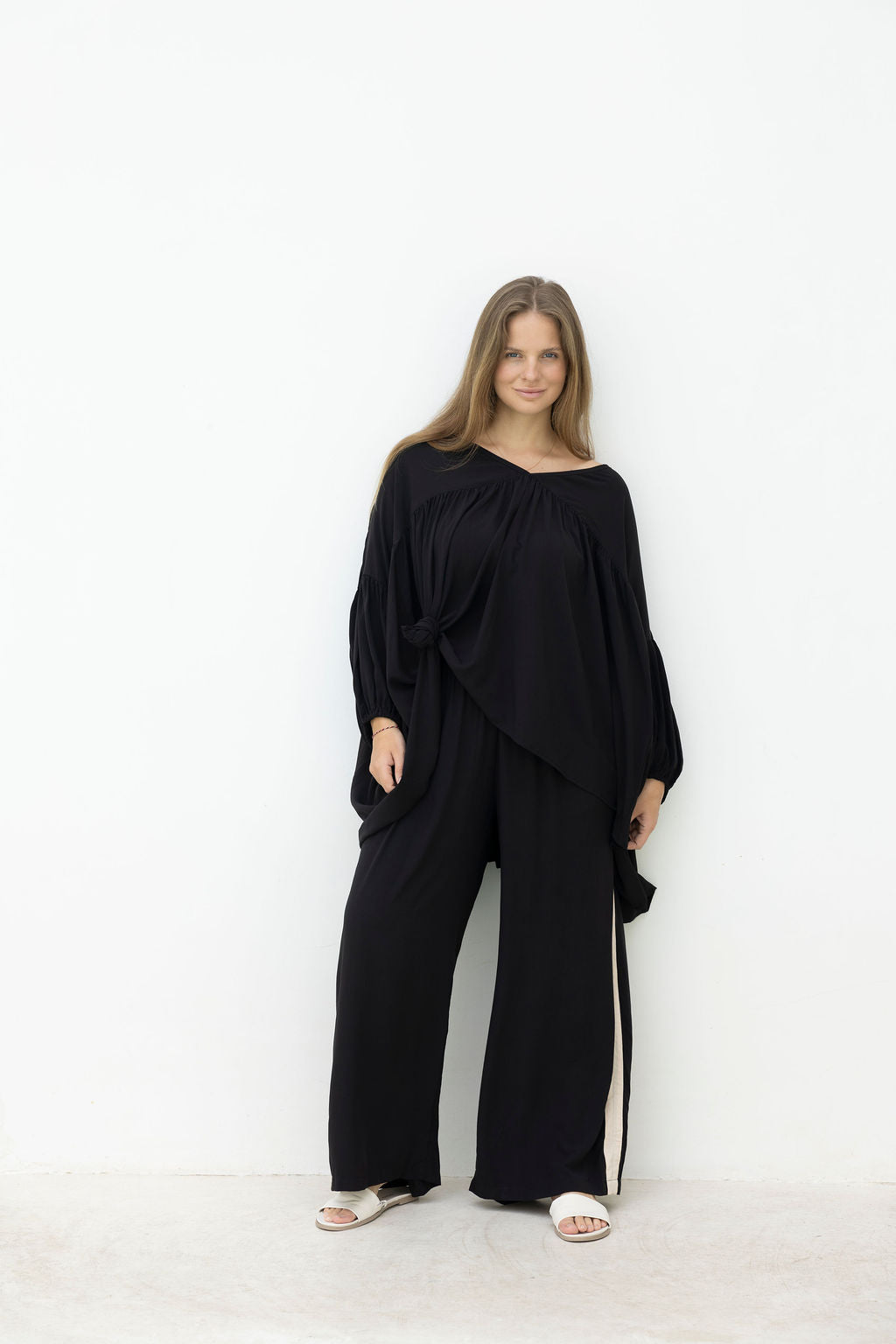 Woman wearing a black outfit against a white background