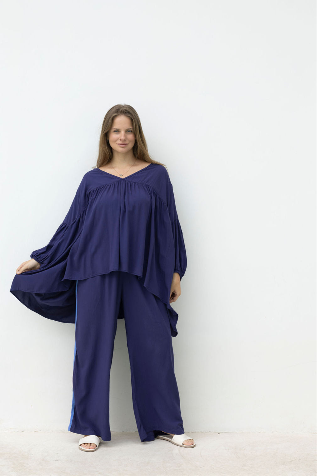 Woman wearing a navy blue outfit against a white background