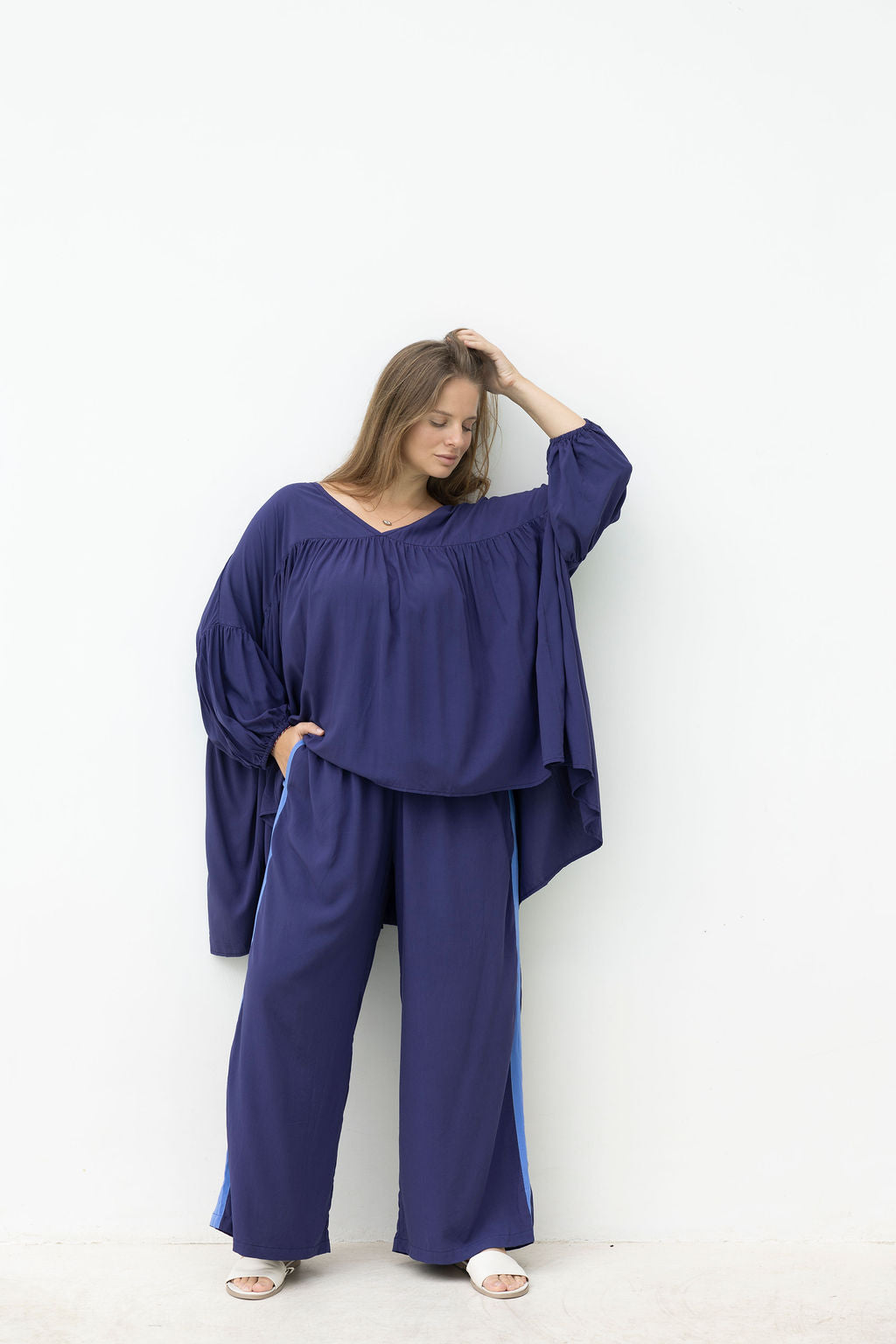 Woman wearing a navy outfit against a white background