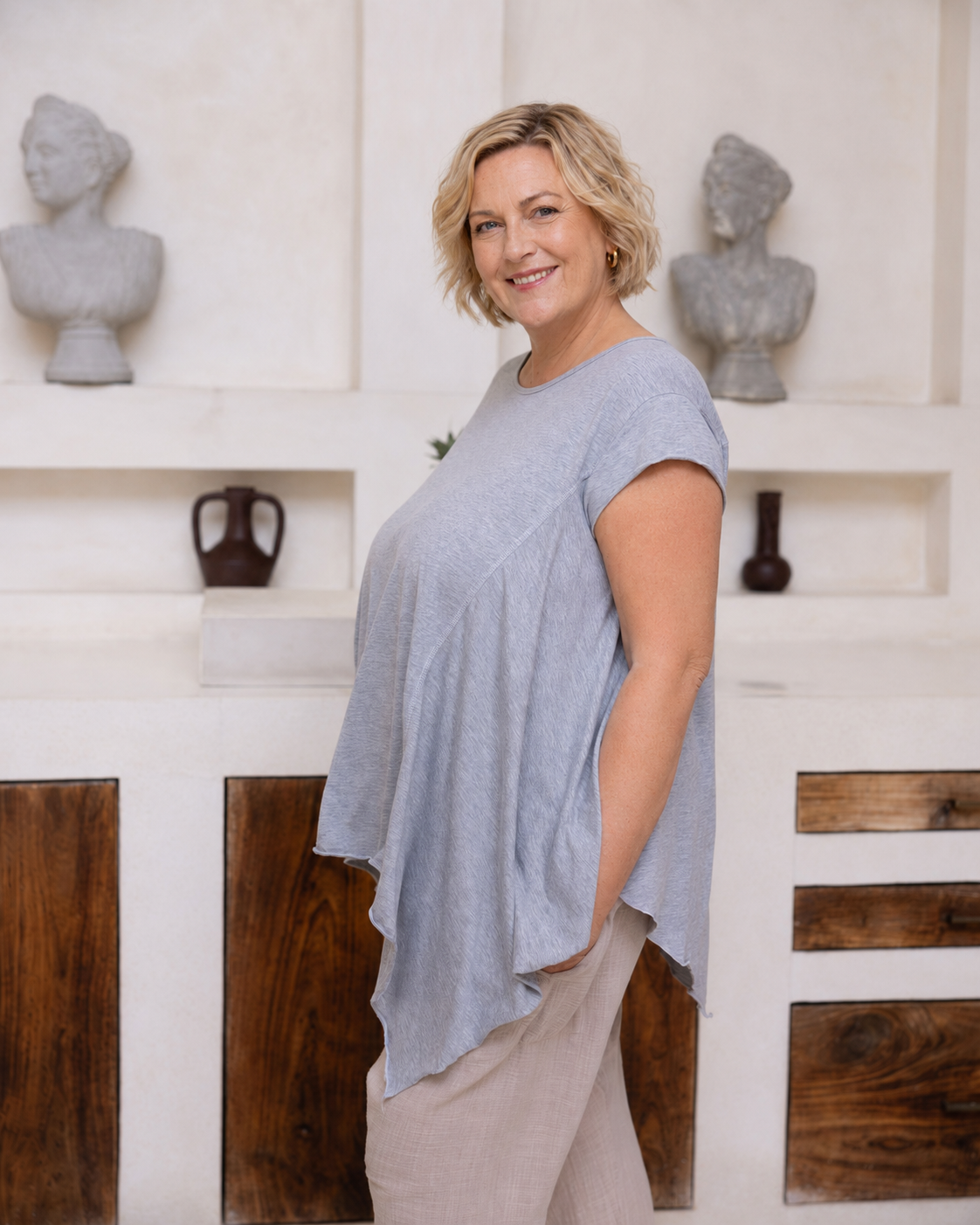 Woman wearing Little Cove Top in Grey Marle. Relaxed oversized fit, asymmetric hemline, 100% cotton.