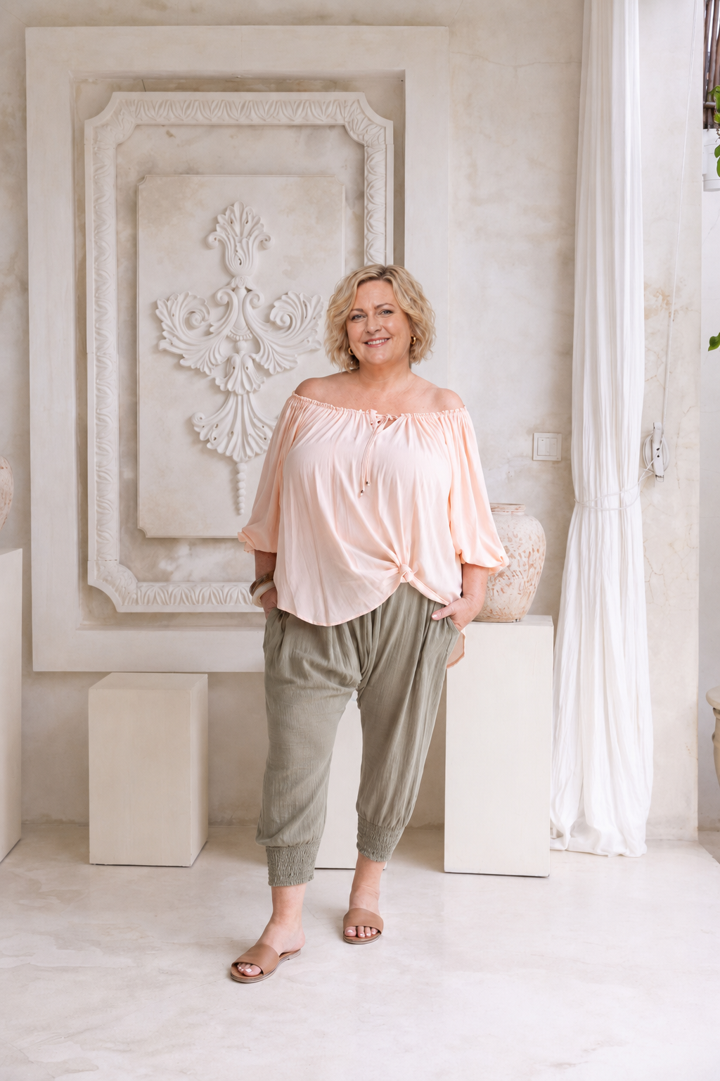 Woman wearing Ouvea Blouse in Blush, relaxed fit, on or off-shoulder styling