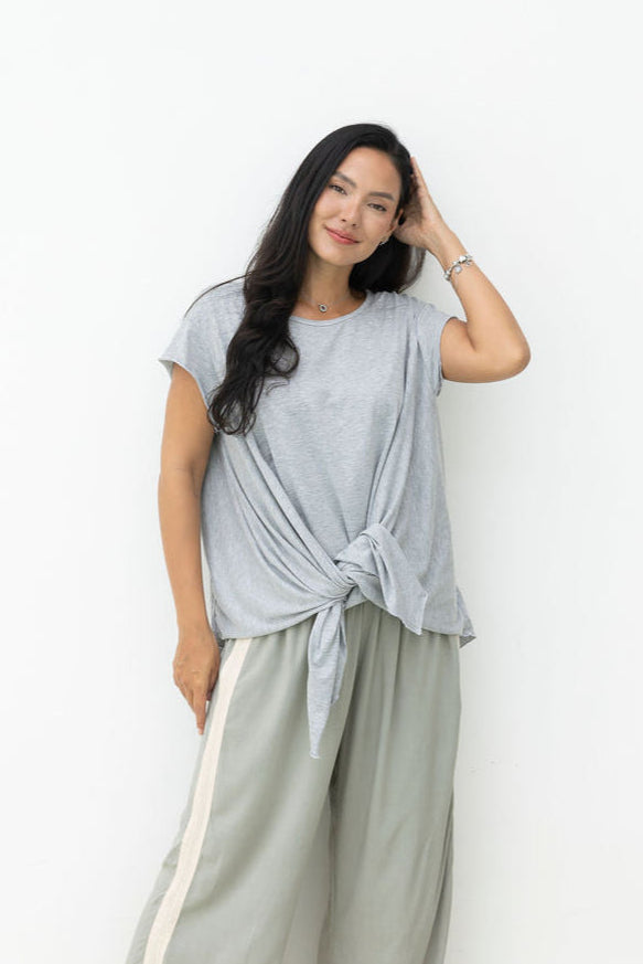 Woman wearing Little Cove Top in Grey Marle. Relaxed oversized fit, asymmetric hemline, 100% cotton.