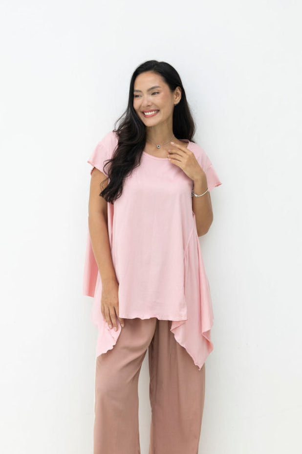 Woman wearing Little Cove Top in Rose. Relaxed oversized fit, asymmetric hemline, 100% cotton.
