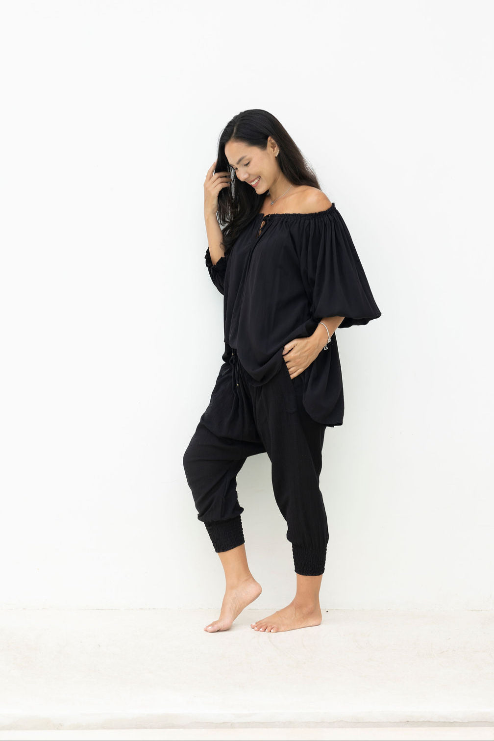 Woman wearing a black outfit against a white background