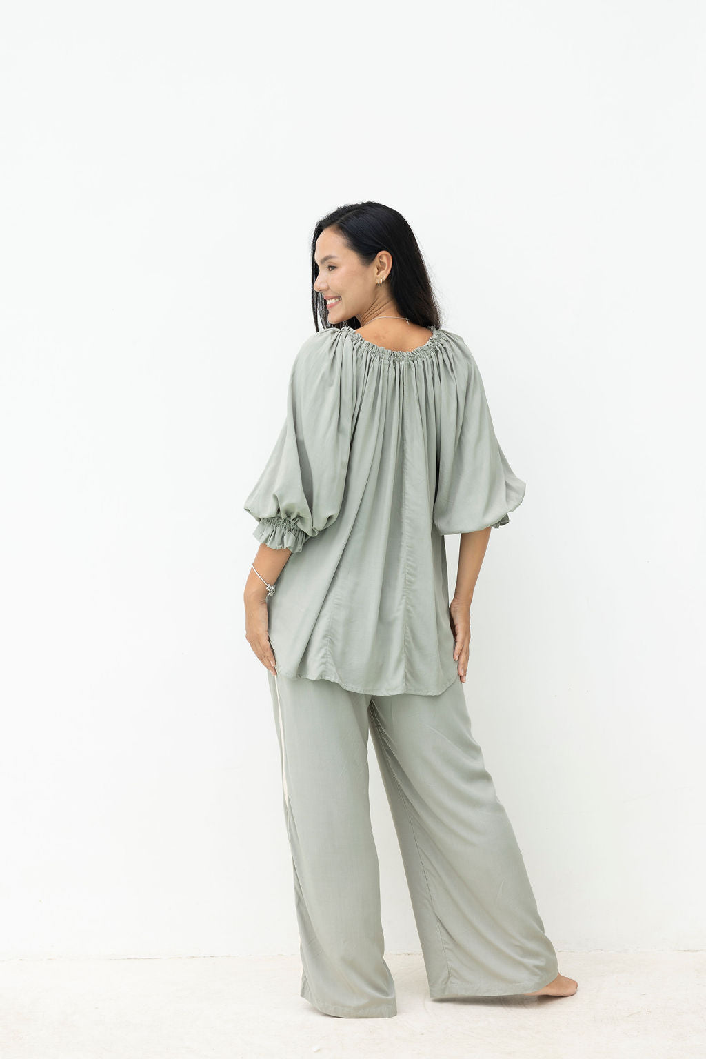 Woman wearing a light green outfit on a white background