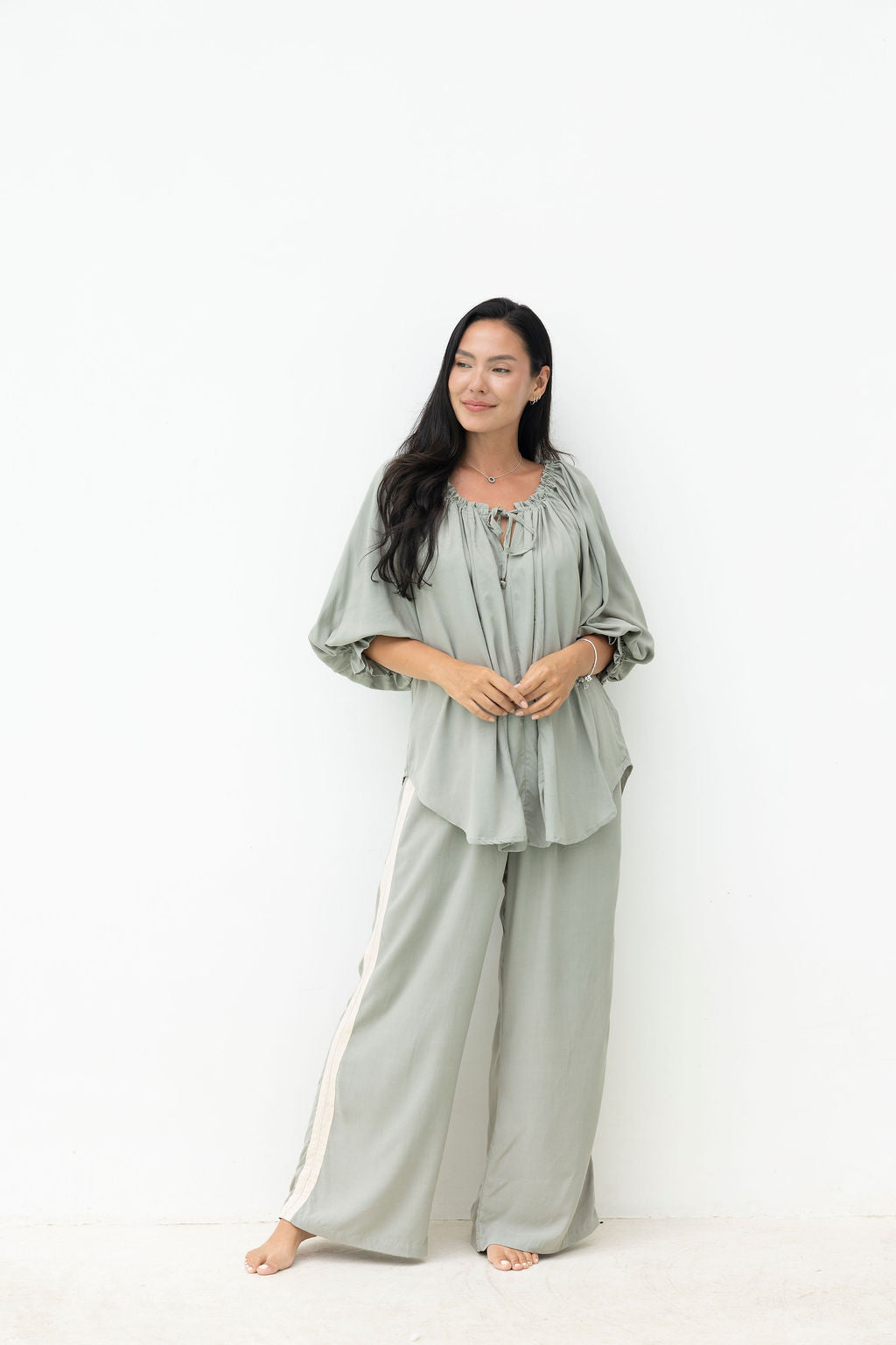 Woman wearing a light green outfit on a white background
