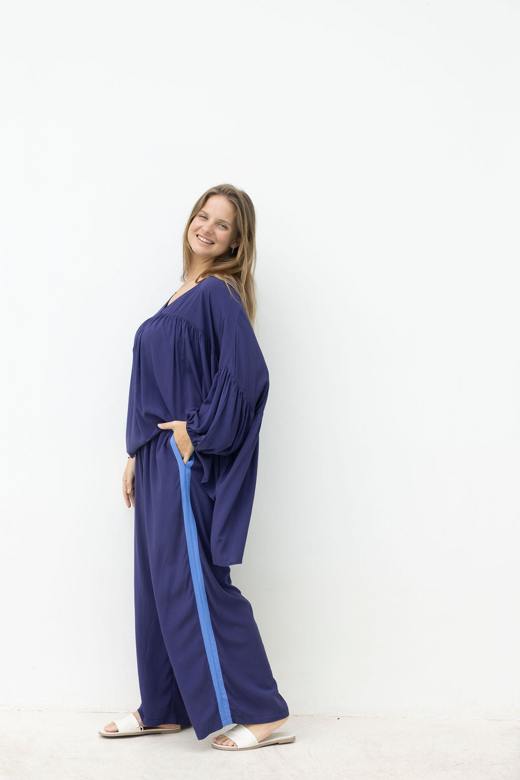 Woman wearing a blue outfit with wide-leg pants on a white background