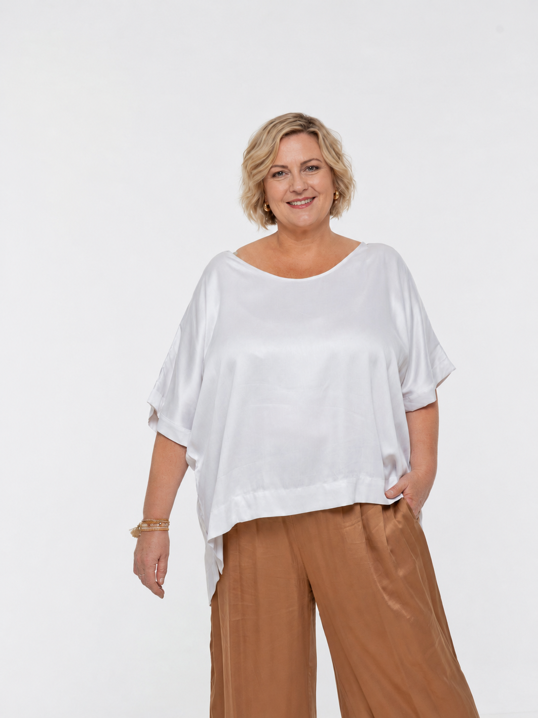 Woman wearing Salina Top in White Sand - Luxe Satin. Relaxed fit, elbow length Dolman sleeve
