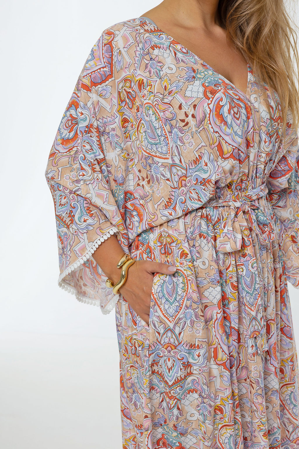 Woman wearing the Bianca Dress in Palazzo Print.  A flowing dress with a wrap-over neckline, elasticated high waist, kimono sleeves and front split.