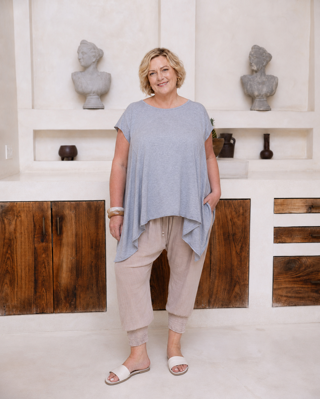 Woman wearing Little Cove Top in Grey Marle. Relaxed oversized fit, asymmetric hemline, 100% cotton.