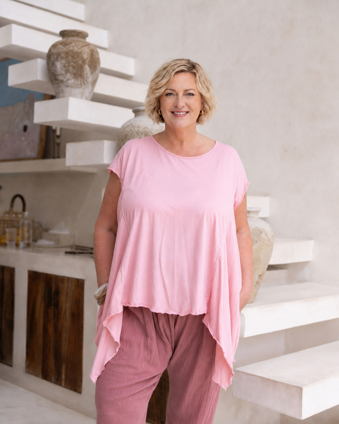 Woman wearing Little Cove Top in Rose. Relaxed oversized fit, asymmetric hemline, 100% cotton.