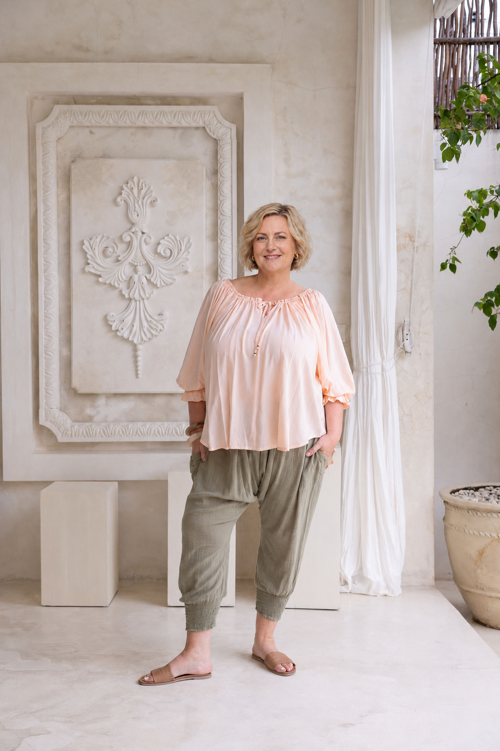 Woman wearing Ouvea Blouse in Blush, relaxed fit, on or off-shoulder styling