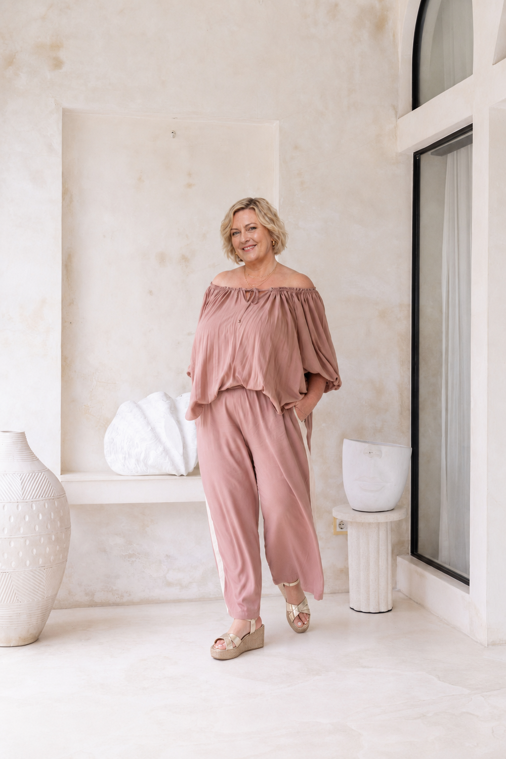 Woman wearing Ouvea Blouse in Mocca, relaxed fit, on or off-shoulder styling