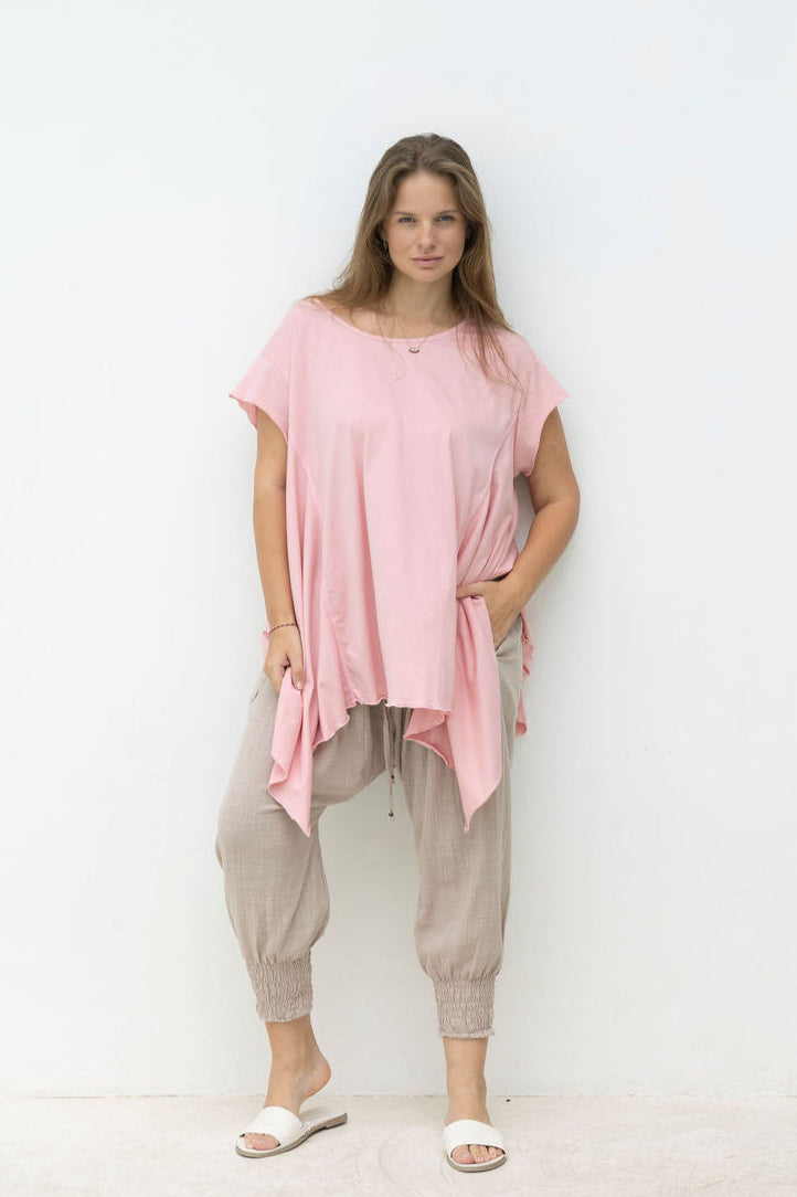 Woman wearing Little Cove Top in Rose. Relaxed oversized fit, asymmetric hemline, 100% cotton.