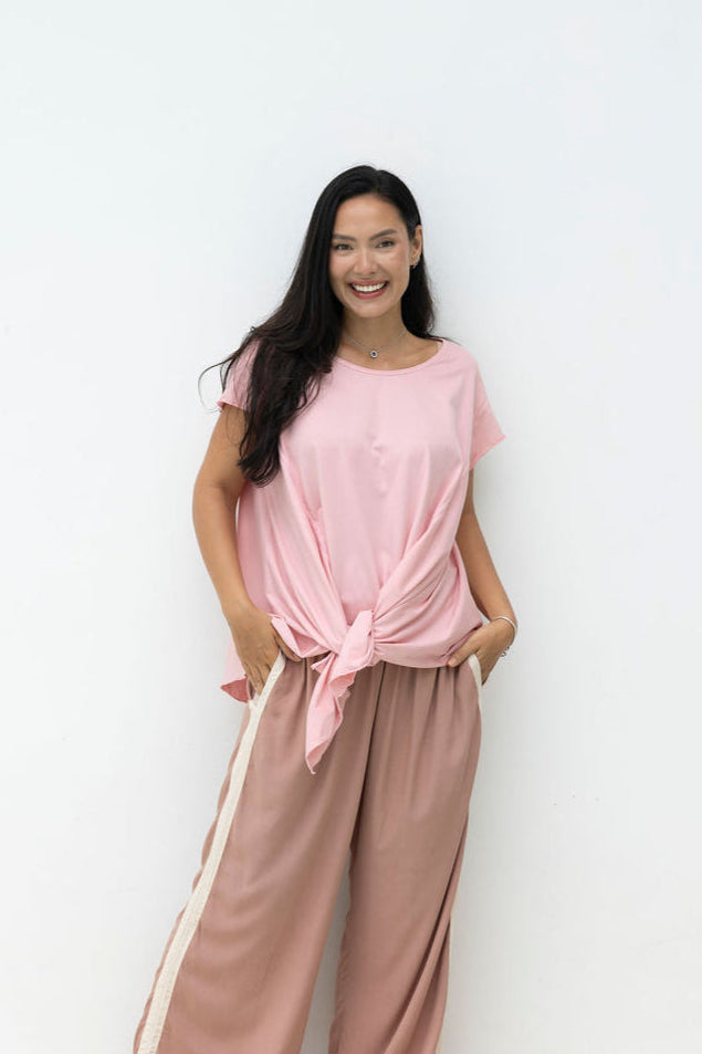 Woman wearing Little Cove Top in Rose. Relaxed oversized fit, asymmetric hemline, 100% cotton.