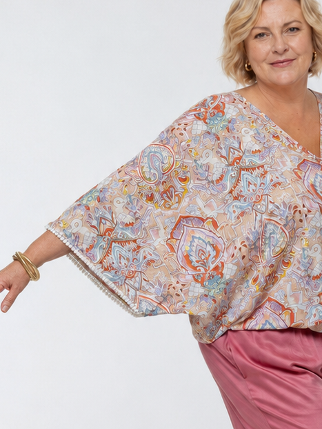 Woman wearing the Messina Top - Palazzo Print.  A flowing printed rayon top with a wrap-over neckline, kimono sleeves, crochet trim, elastic waist with adjustable tie