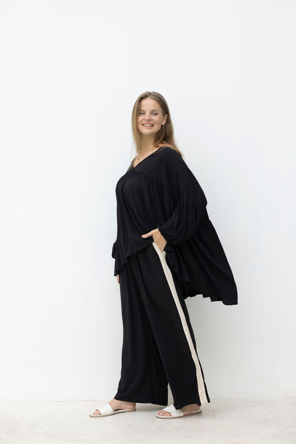 Woman wearing the Perfect Tuxedo Pant in Black with Stone Stripe, fluid wide-leg fit, effortlessly elevated style