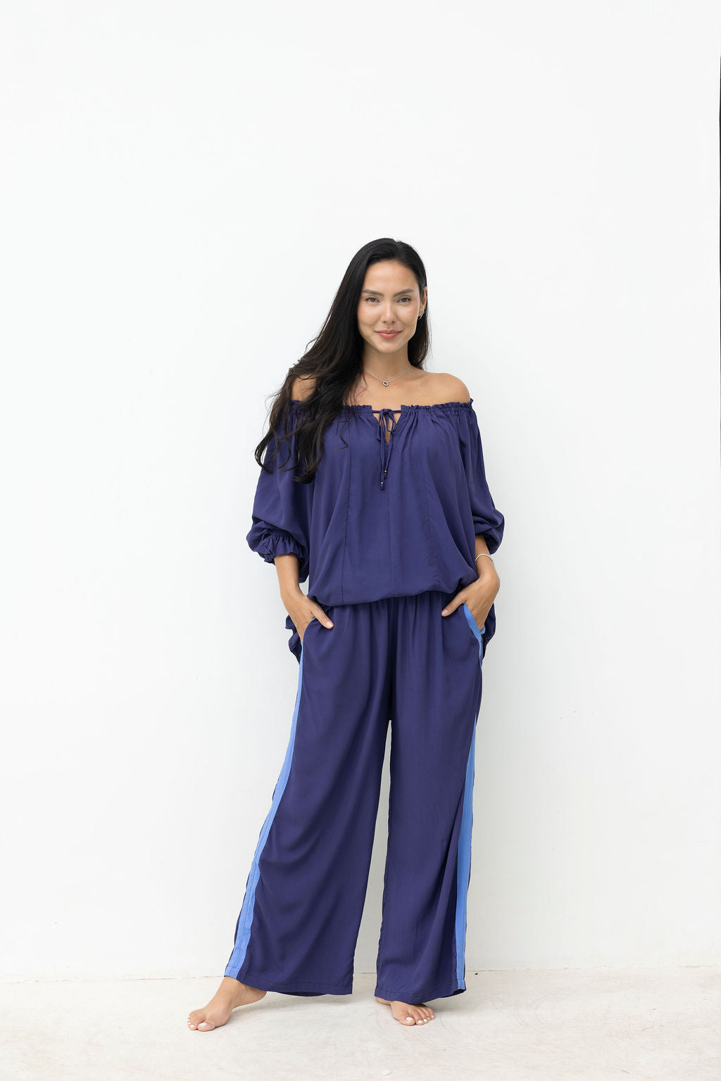 Woman wearing a blue outfit with wide-leg pants on a white background