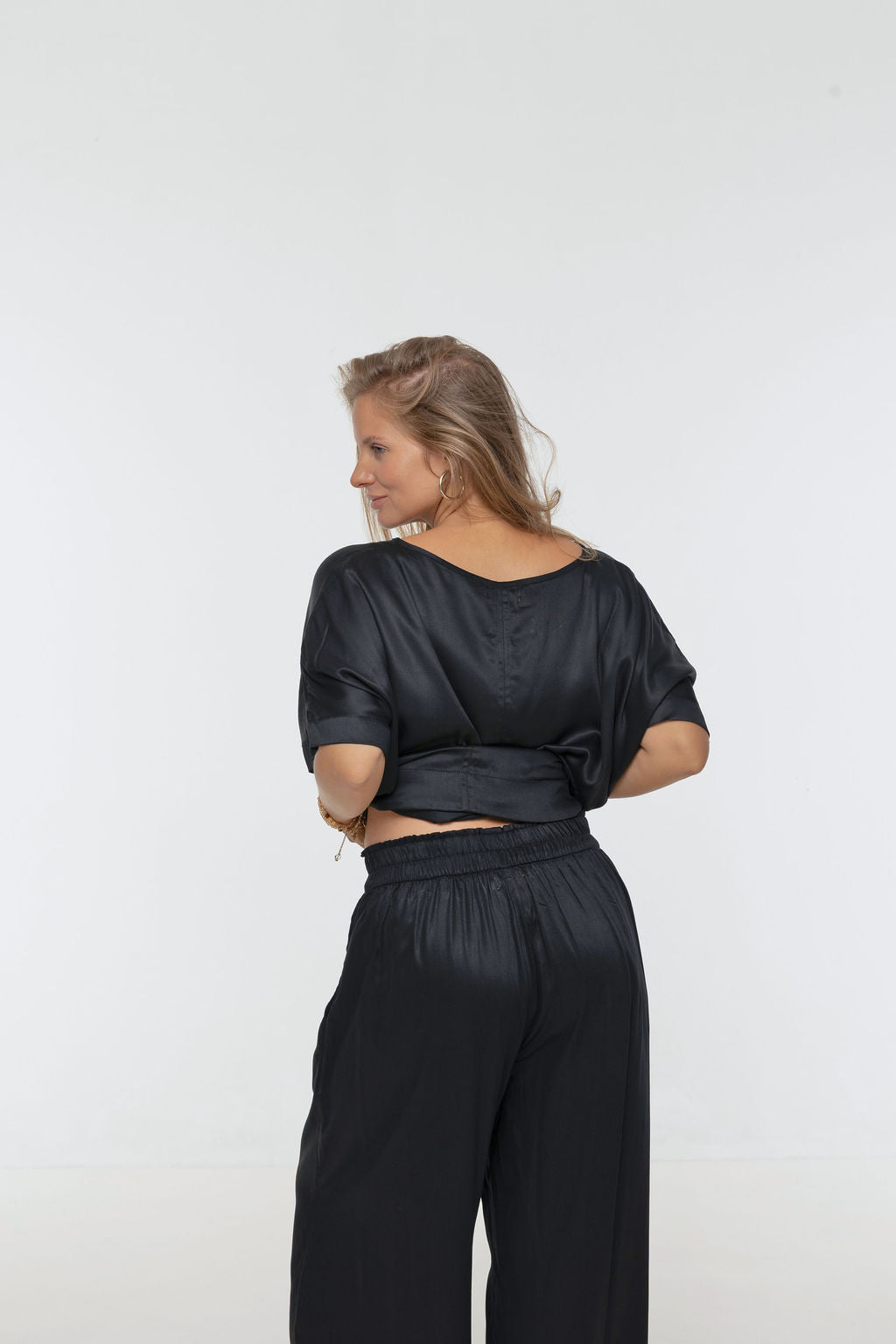 Woman wearing Rimini Pant in Black - Luxe Satin.  Wide leg style, relaxed fit.