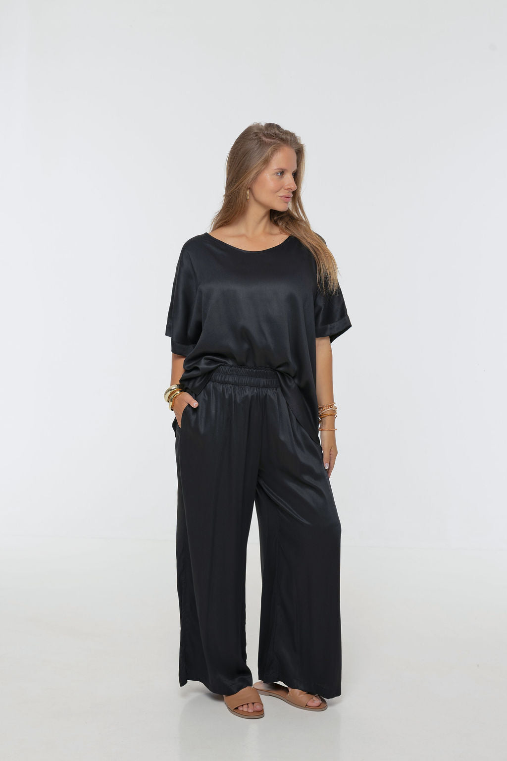 Woman wearing Rimini Pant in Black - Luxe Satin.  Wide leg style, relaxed fit.
