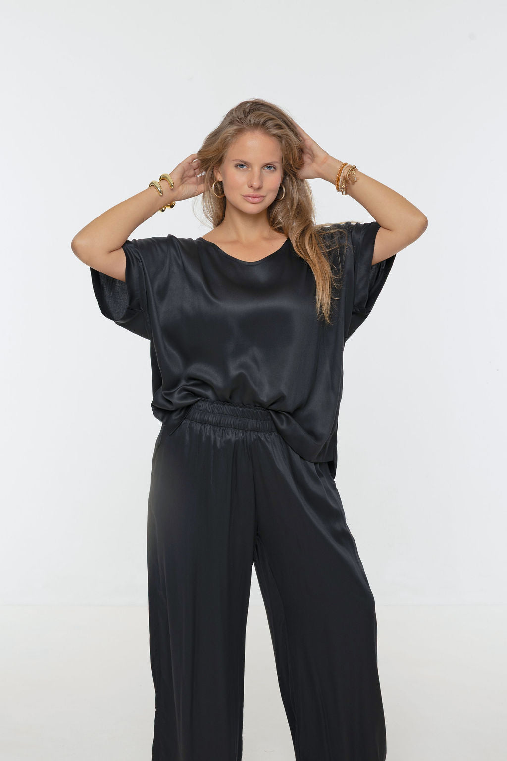 Woman wearing Salina Top in Black - Luxe Satin.  Relaxed fit, elbow length Dolman sleeve 